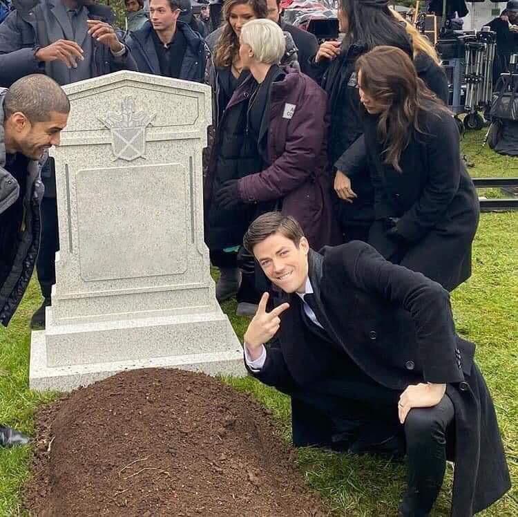 Grant Gustin posing at a fake grave